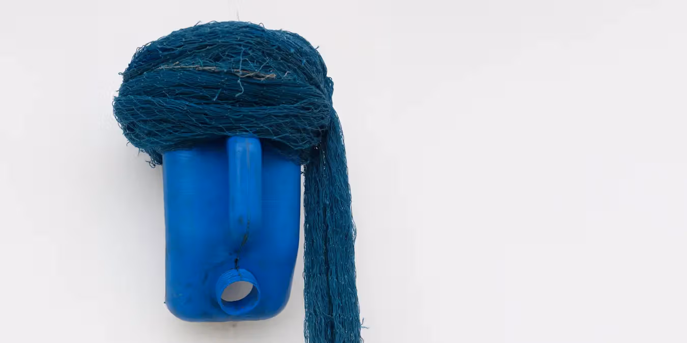 Blue container mask with fibres piled above and falling to one side