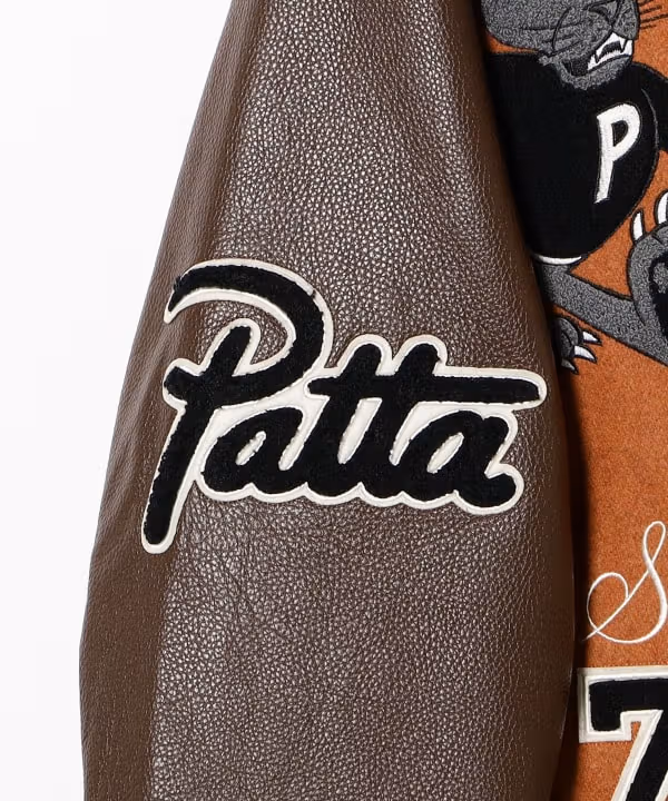 牛革のシボとワッペンの厚みが見える袖のPattaロゴ。